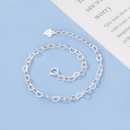Silver chain bracelet on a light blue background