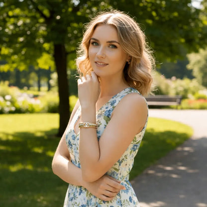 Woman in a floral dress standing in a park with trees and grass in the background