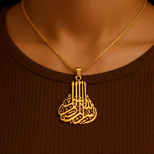 Gold necklace with a detailed pendant on a brown background