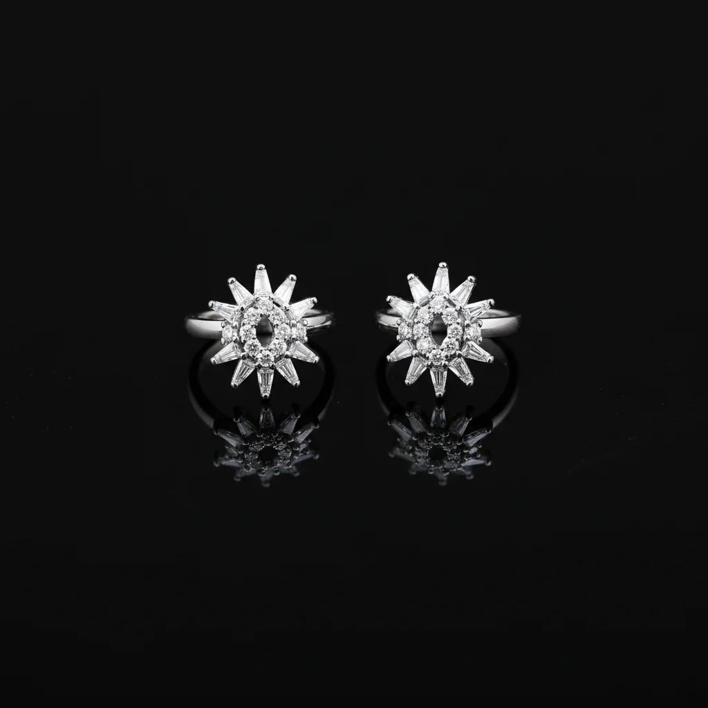 Star-shaped silver earrings with clear stones on a black background