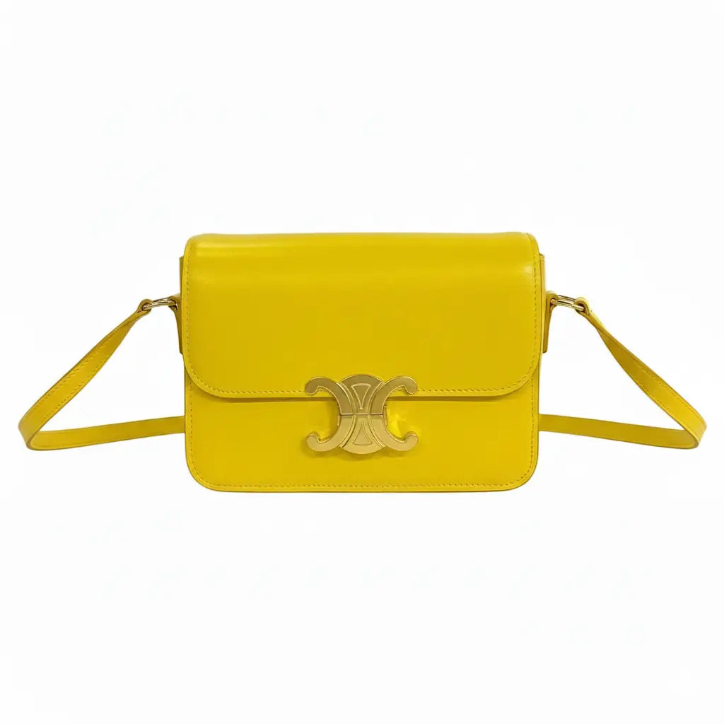 Yellow handbag with a gold emblem on a white background