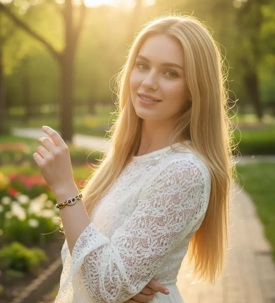 Woman in a white lace dress standing in a park with sunlight filtering through the trees.