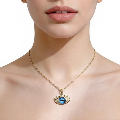 Gold necklace with an eye-shaped pendant worn by a person on a white background