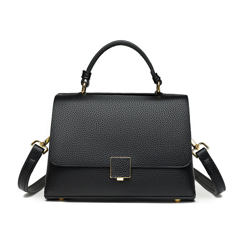Black handbag with gold accents on a white background