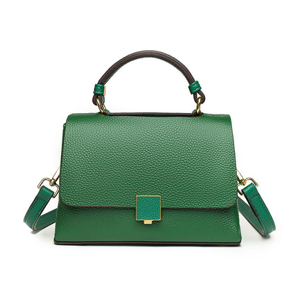 Green handbag with gold accents on a white background