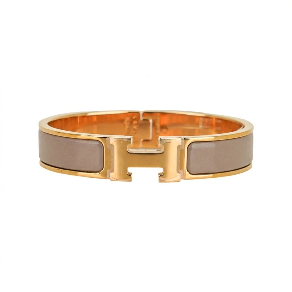 Gold bracelet with beige accents on a white background