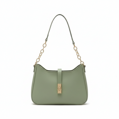 Green handbag with gold clasp on a light beige fabric background