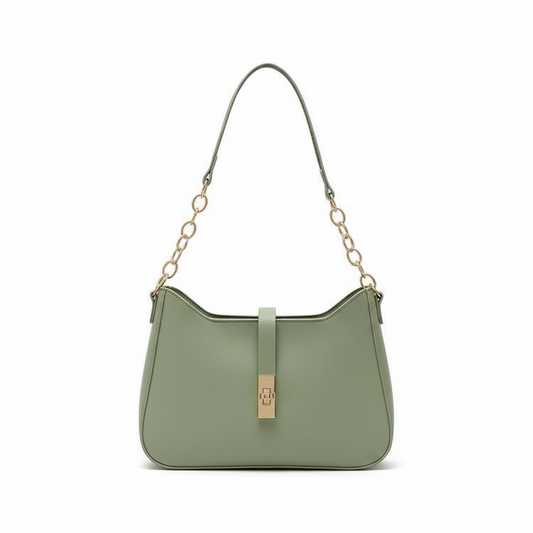 Green handbag with gold clasp on a light beige fabric background