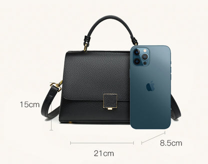Black handbag with measurements and an iPhone 11 Pro Max for scale on a white background