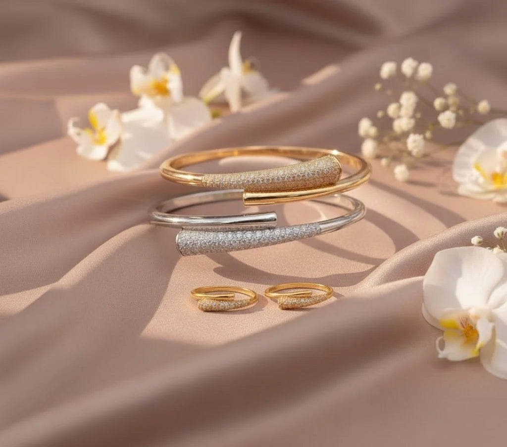 Gold and silver bracelets on a beige fabric background with flowers.