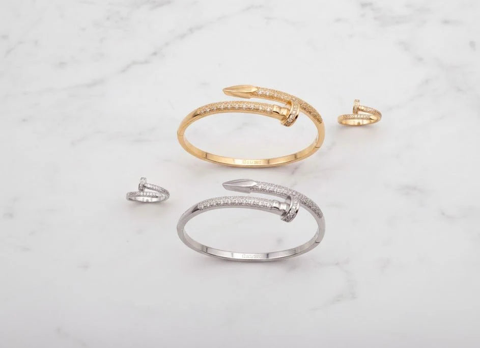 Gold and silver open bracelets on a marble surface