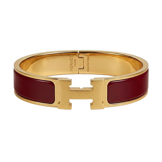 Gold bracelet with beige accents on a white background