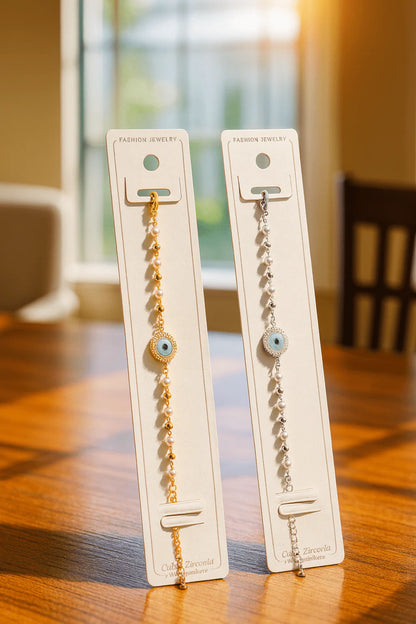 Two bracelets on display cards on a wooden surface with a blurred background