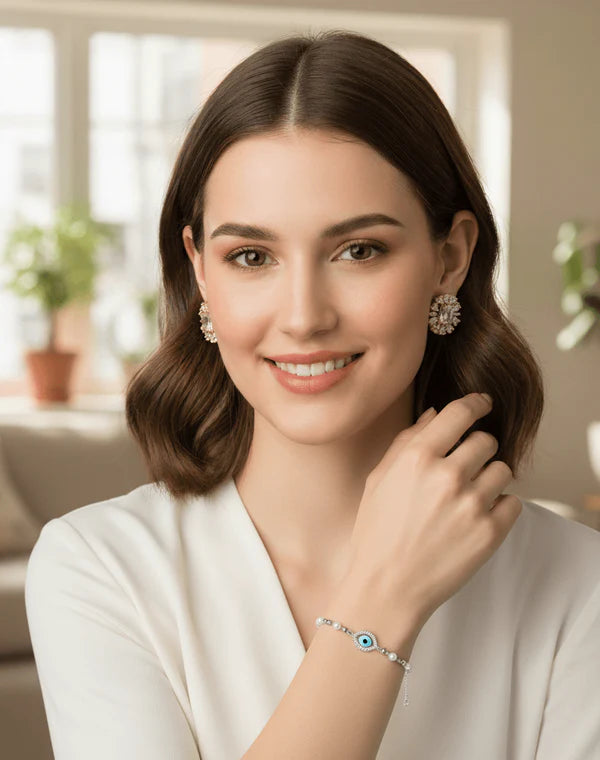 Woman wearing earrings and a bracelet indoors with a blurred background